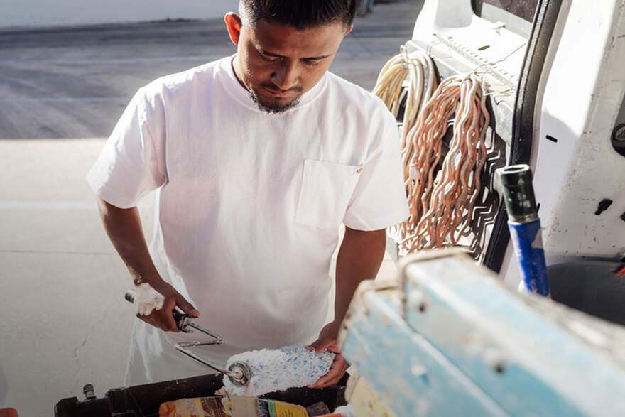 Man in white tee shirt with paint roller