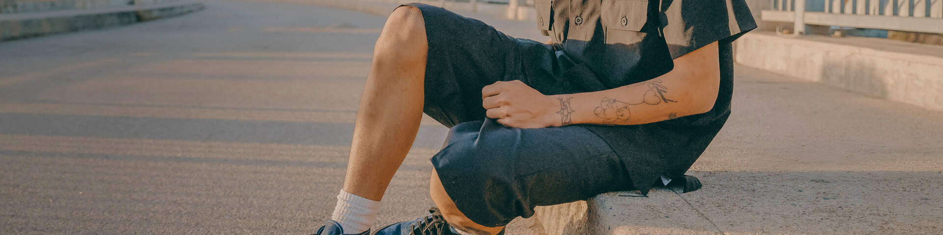 Young man sitting on bridge