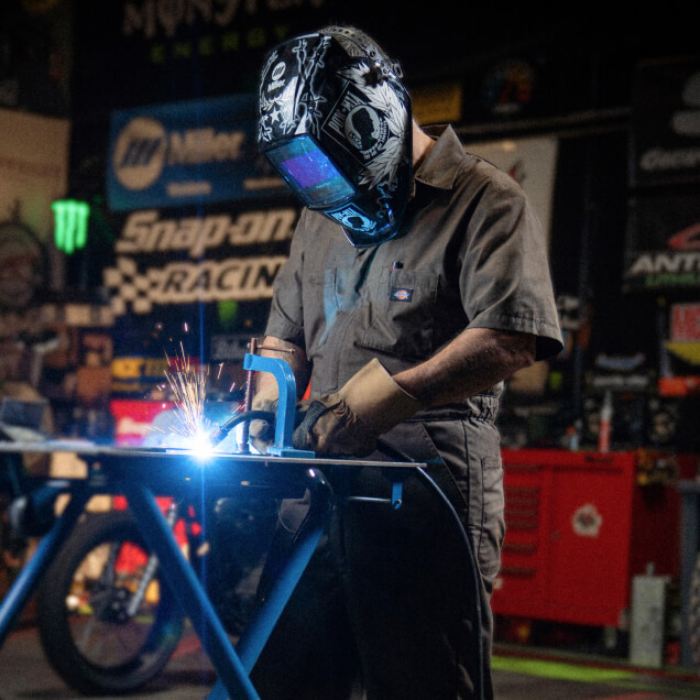 A worker welding two pieces of metal together.