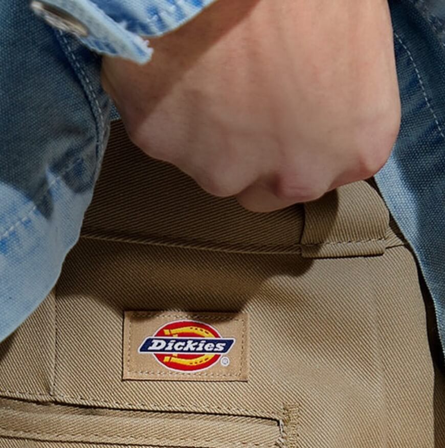4 Dickies logo patches on a twill background ranging from the 1920s to the 1980s.