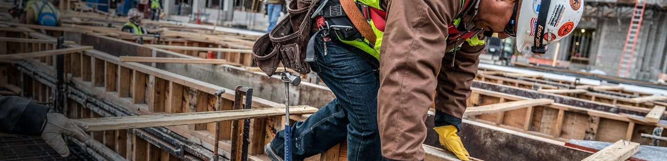 man picking up lumber
