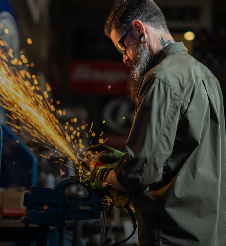 A worker using a tool and making sparks fly.