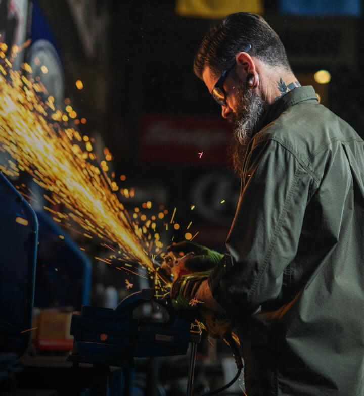 A worker making sparks fly from a tool.
