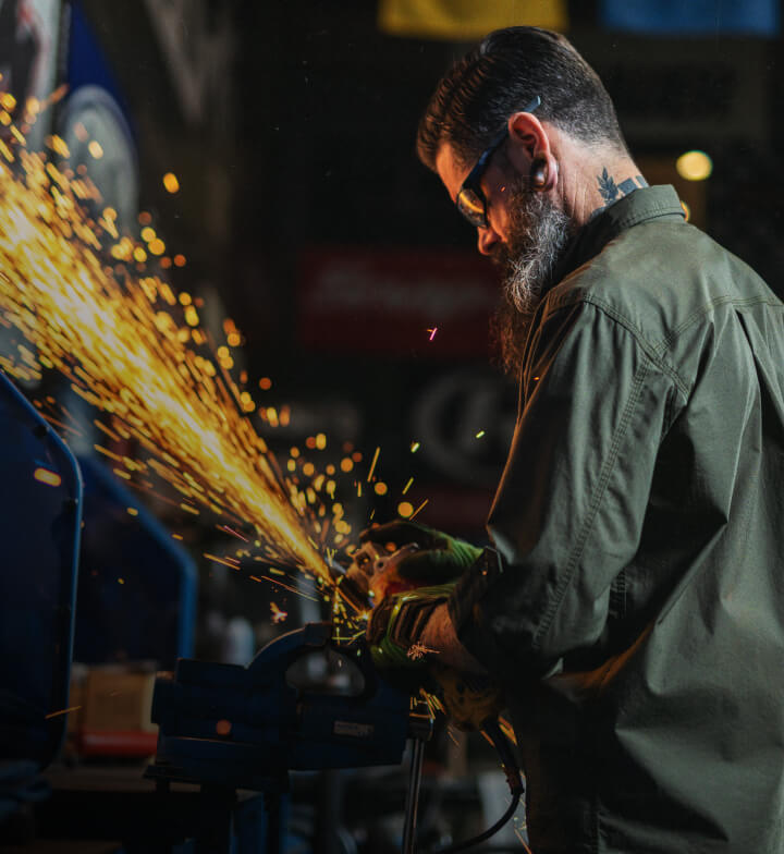 A worker making sparks fly from a tool.