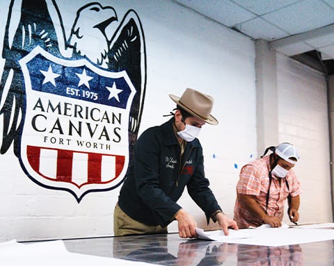 two men wearing masks and standing over a table