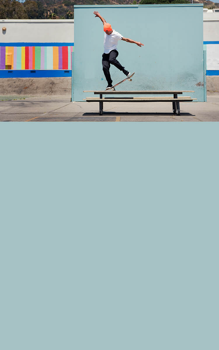 a man doing a skateboard trick on a bench table