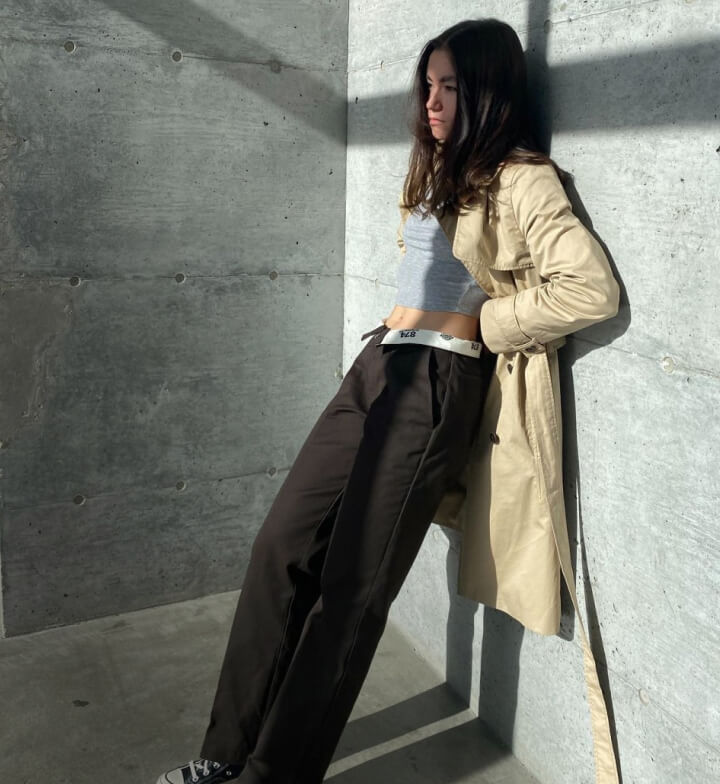 a woman leaning her back on a wall wearing womens 874 jeans