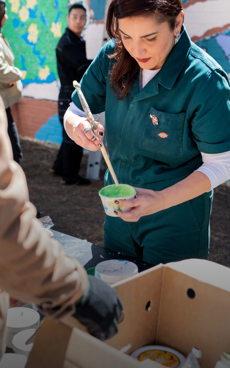 a person holding a cup while mixing green liquid