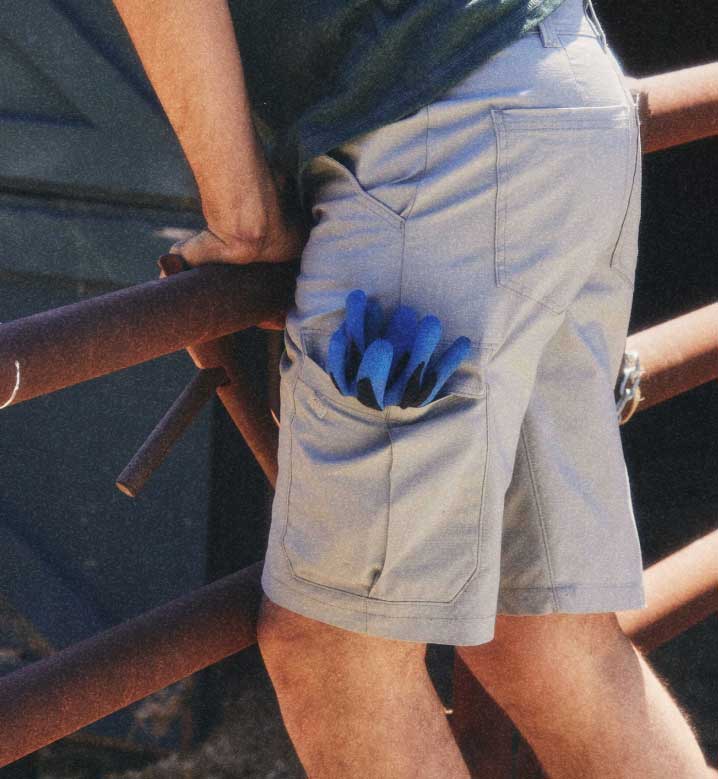 A worker putting vegetables in a bowl while wearing a green Dickies T-shirt.