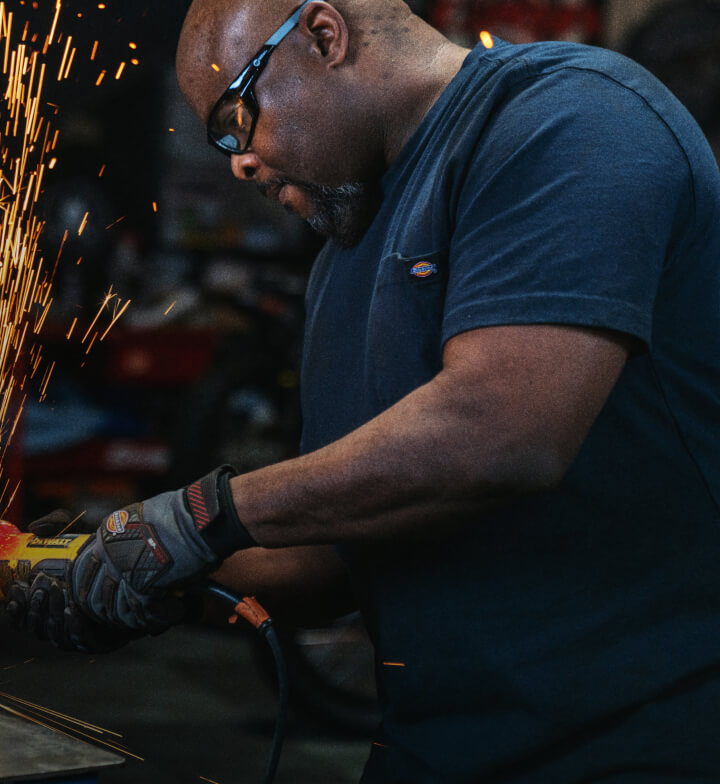 A man using an electric tool in a workshop.