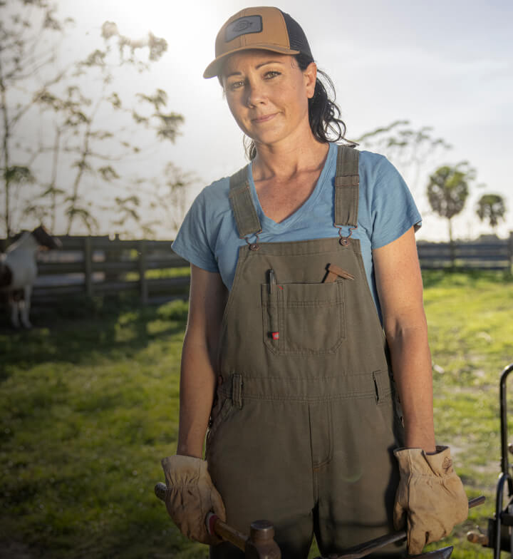 a woman standing outside in a farm